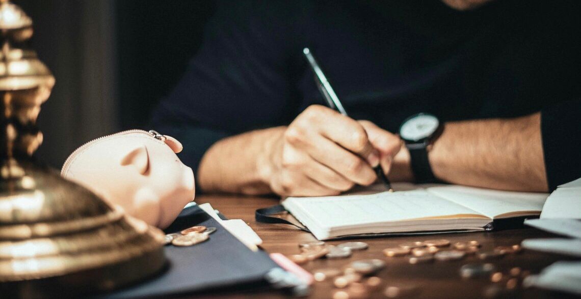 Uma pessoa fazendo cálculos no caderno
